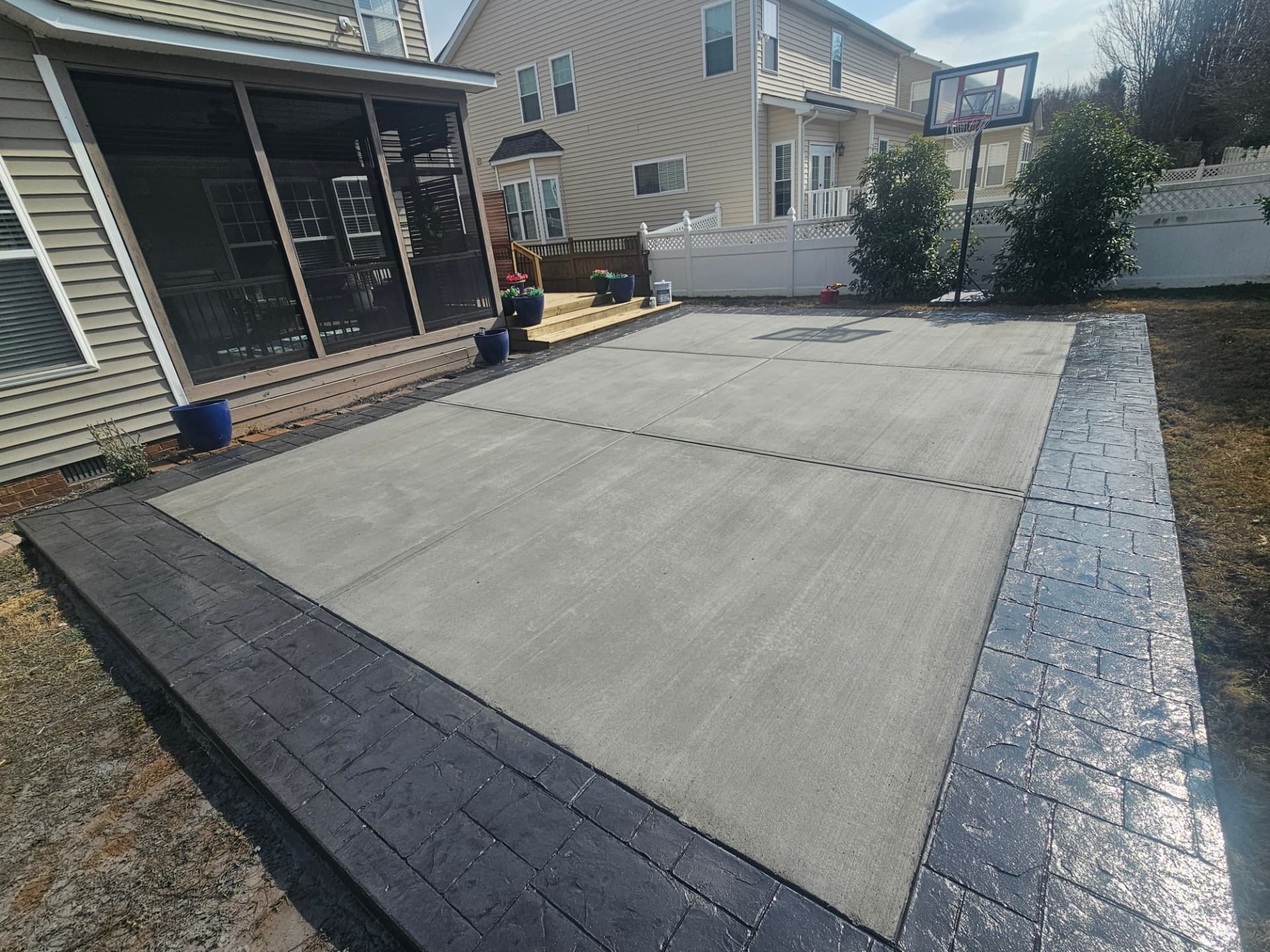 Concrete backyard patio with a dark stamped border
