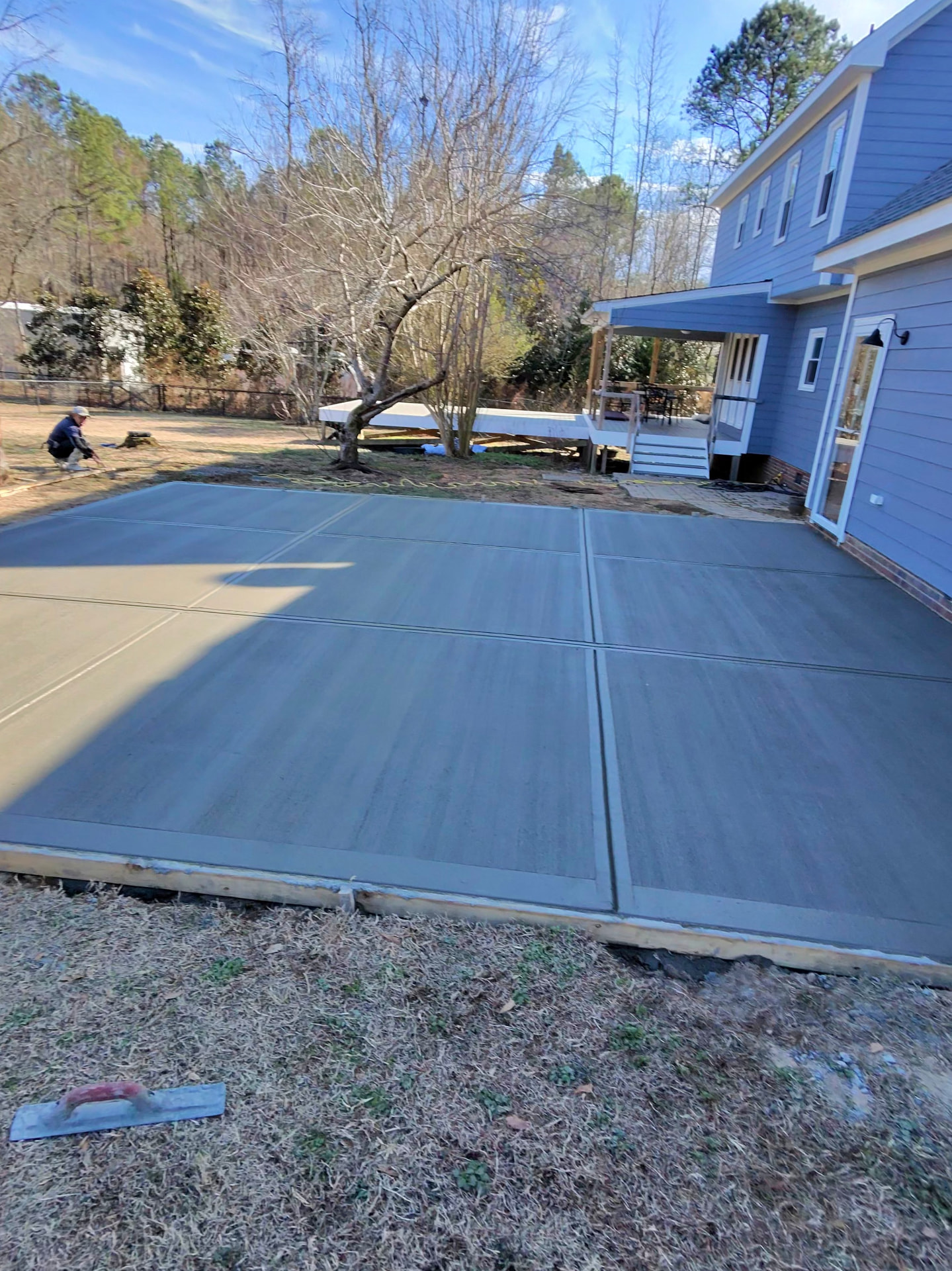 Fresh concrete patio beside a blue house
